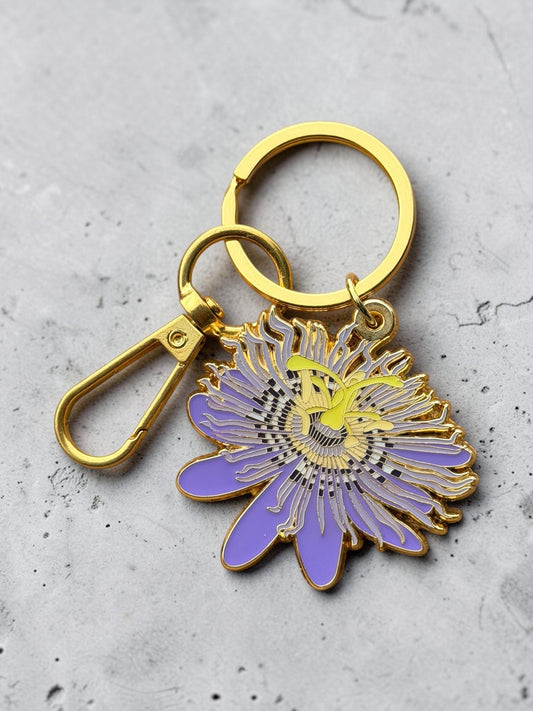 The Plant Ecologist Maypop Passion Flower hard enamel keychain with purple and yellow details on a gold key ring.