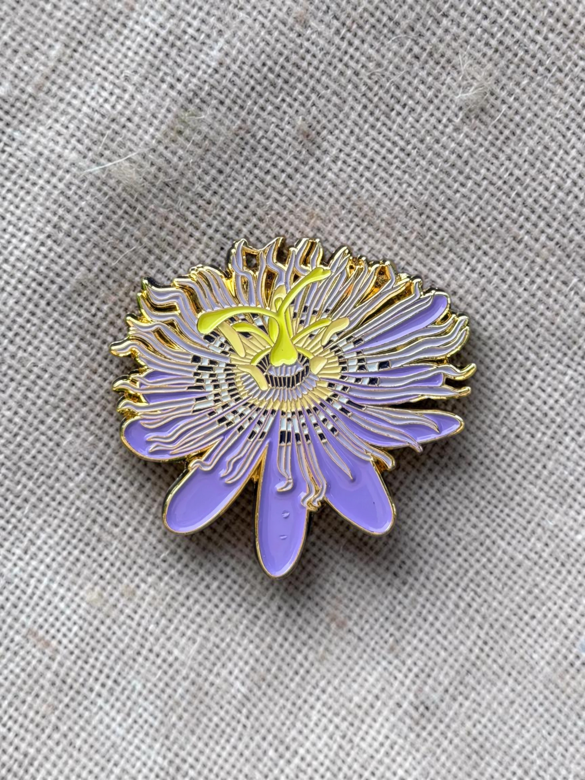 The Plant Ecologist Maypop passion flower enamel pin featuring purple and yellow details on a branded display card.